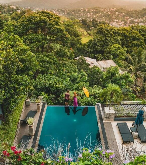 Serene infinity pool at Theva Residency amid lush Hanthana greenery